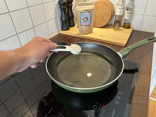 Fettbort-pulver hälls i stekpanna med varm använd matolja